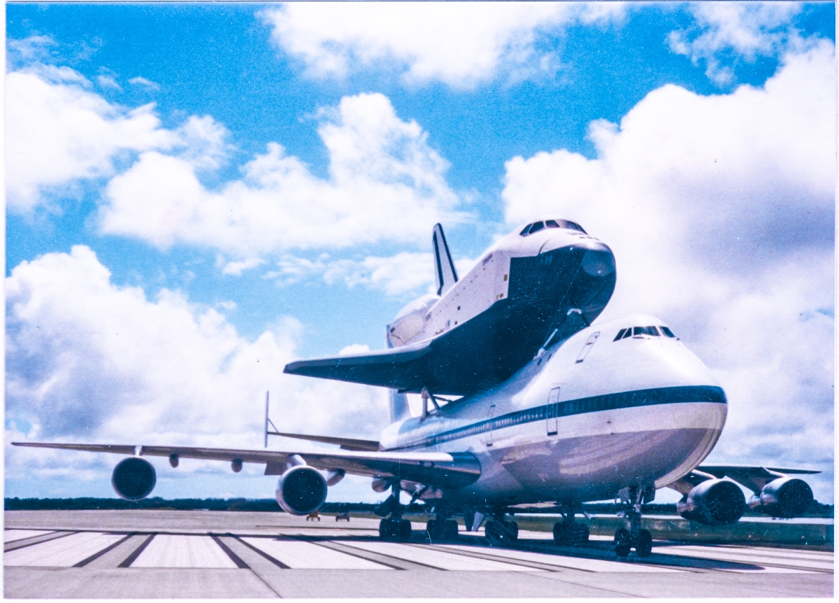 The Space Shuttle Enterprise, OV-101, looming above the tarmac at the south end of the runway at the Shuttle Landing Facility, Kennedy Space Center, Florida, perched atop the 747 Carrier Aircraft which was used to ferry orbiters cross country.